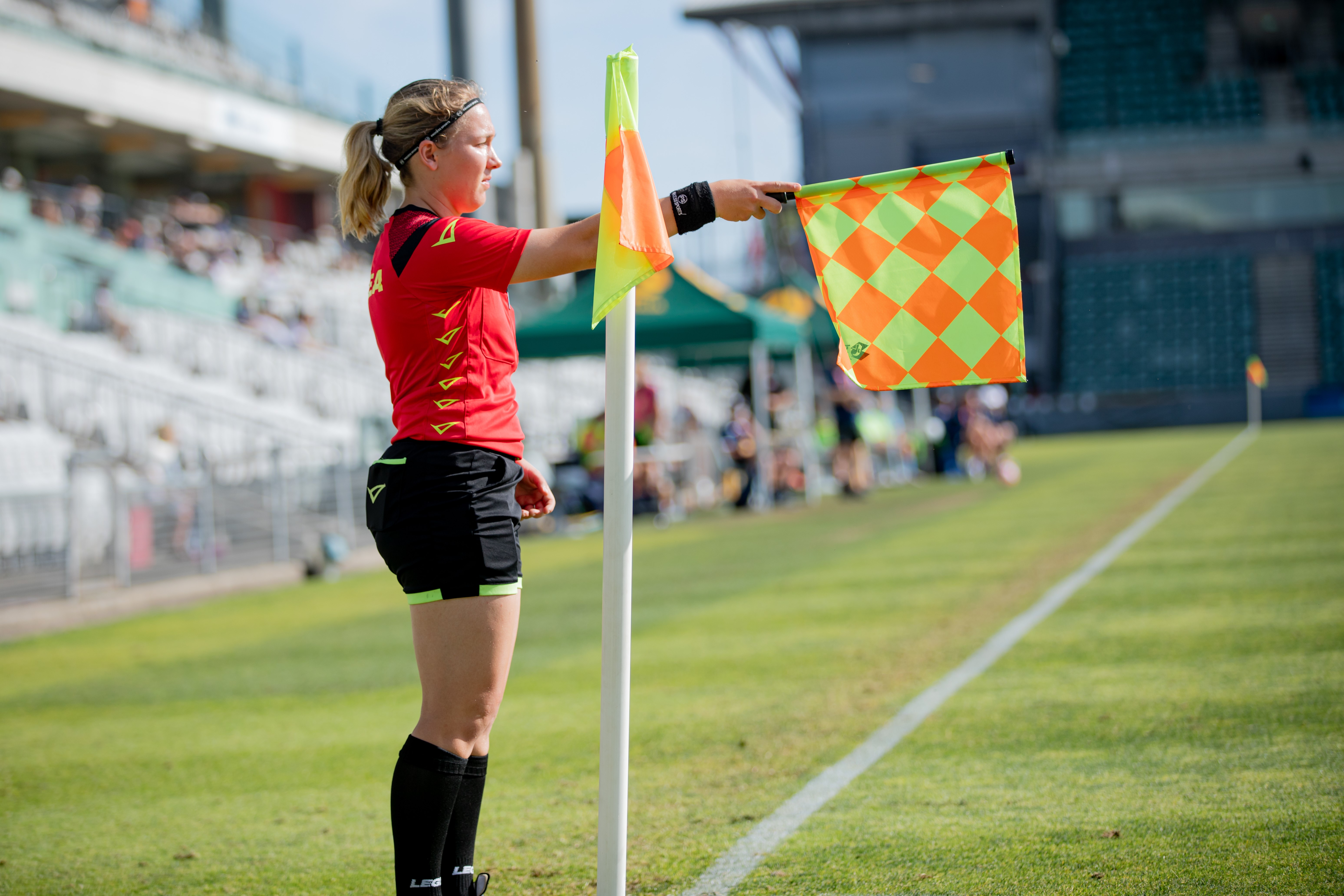 A soccer referee stands holding a flag