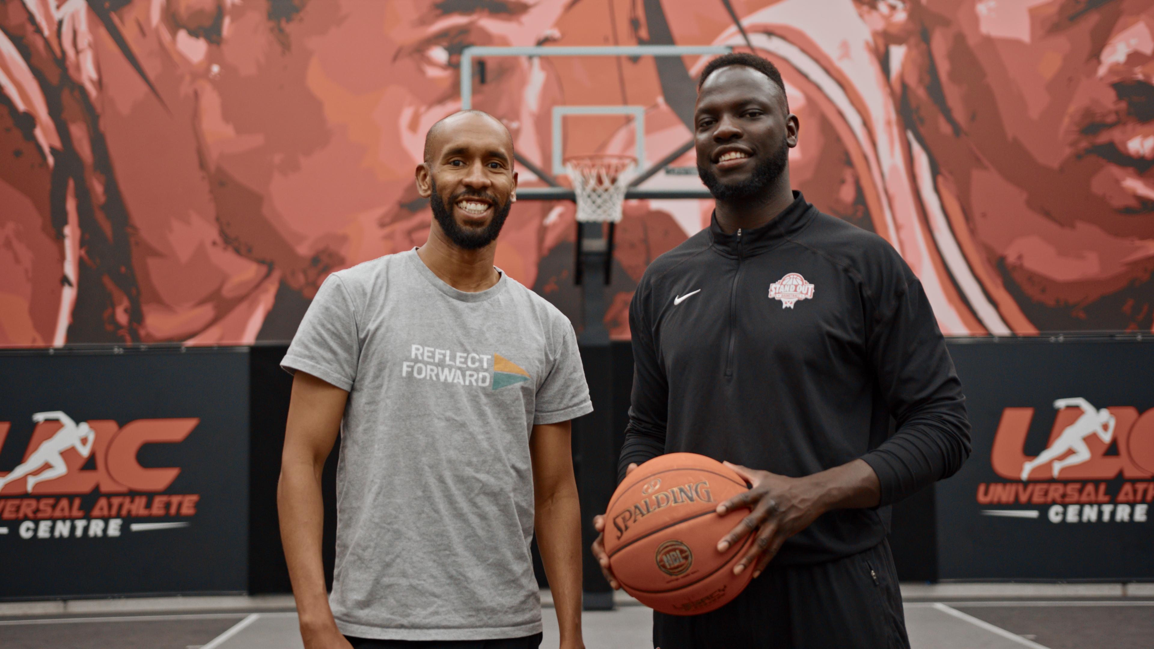 Two basketballers standing in front of a basketball hoop