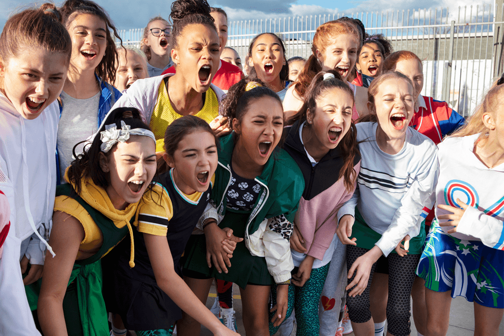 A group of girls cheer while playing sport
