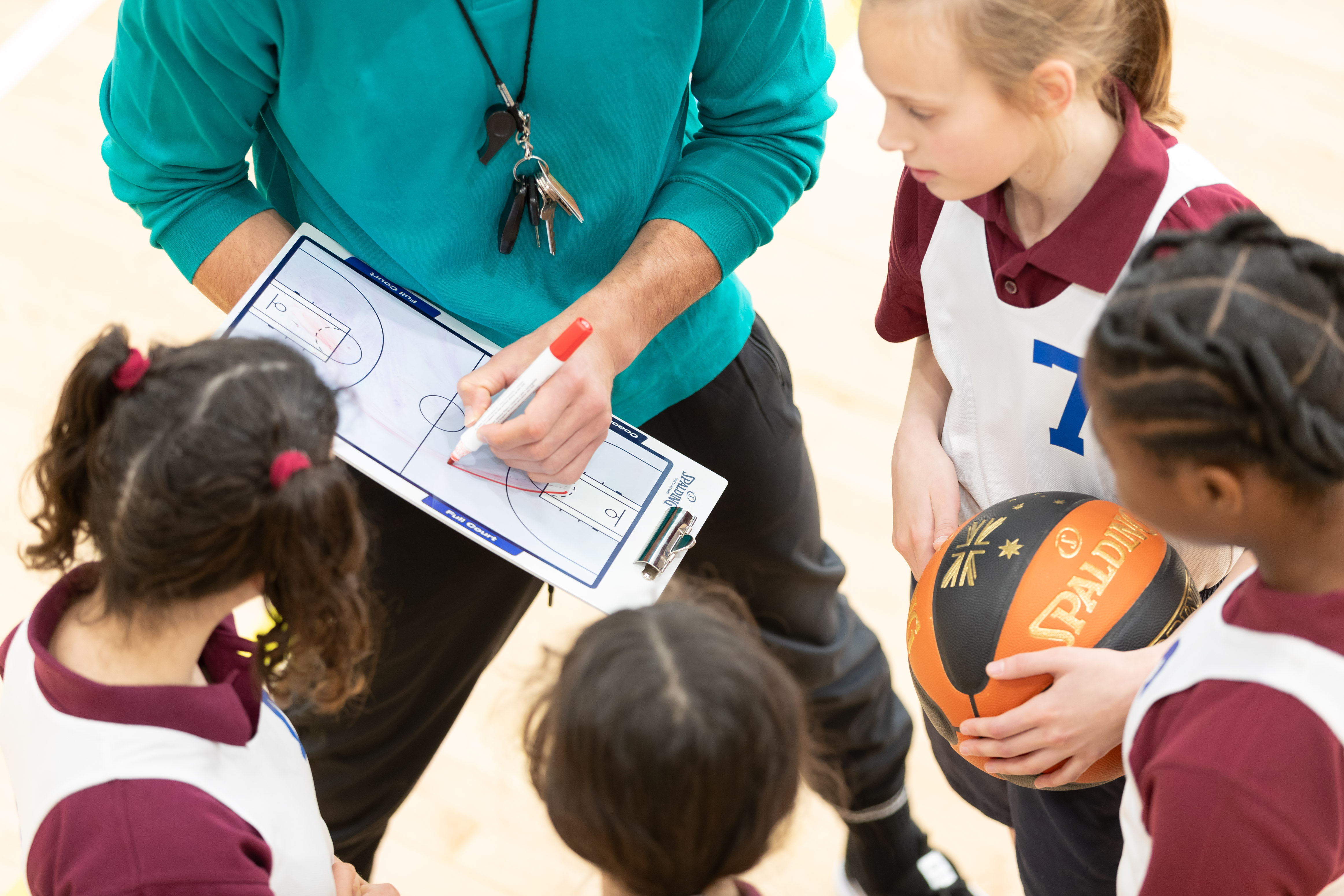 Young basketball players discussing match tactics with their coach